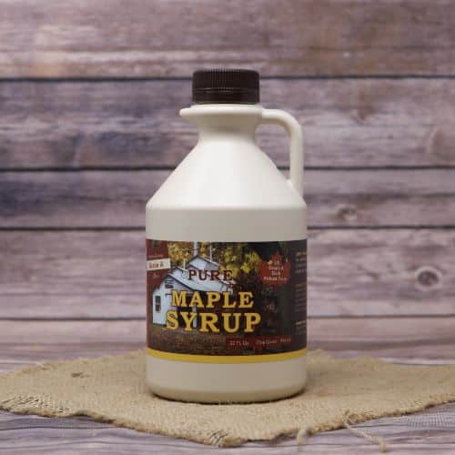 A quart sized bottle of Pure Ohio Maple Syrup, set on rustic burlap with a wooden background.