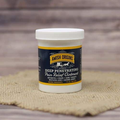 A 7 oz container of Amish Origins Deep Penetrating Pain Relief Ointment, set on rustic burlap with a wooden background.