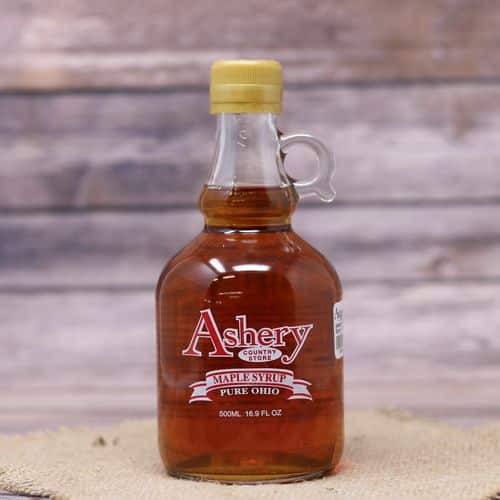 A 16.9 oz size glass bottle of Pure Ohio Maple Syrup, set on rustic burlap with a wooden background.