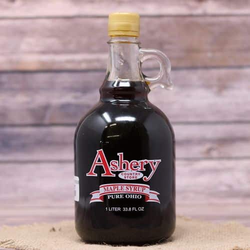 A 33.8 oz size glass bottle of Pure Ohio Maple Syrup, set on rustic burlap with a wooden background.