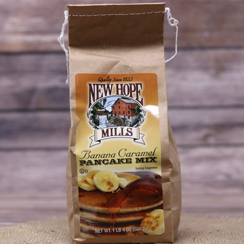 A bag of Banana Caramel Pancake Mix on rustic burlap with a wooden background.