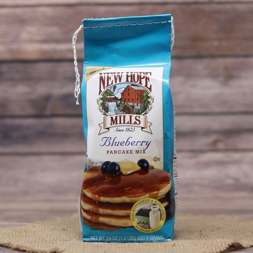 A bag of Blueberry Pancake Mix on rustic burlap with a wooden background.