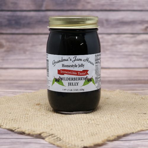 A pint size glass jar of Grandma's Jam House Elderberry Jelly, on rustic burlap with a wooden background.