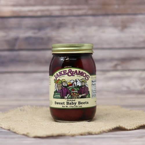 A pint size glass jar of Jake & Amos Pickled Sweet Baby Beets, on rustic burlap with a wooden background.
