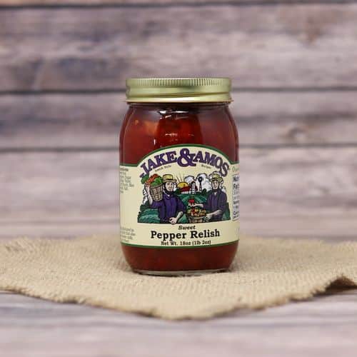 A pint size glass jar of Jake & Amos Sweet Pepper Relish, on rustic burlap with a wooden background.