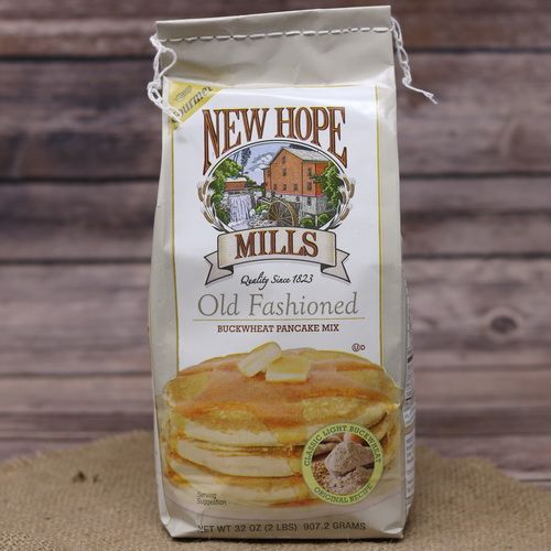 A Bag of Old Fashioned Buckwheat Pancake Mix on rustic burlap with a wooden background.
