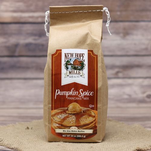 A bag of Pumpkin Spice Pancake Mix on rustic burlap with a wooden background.