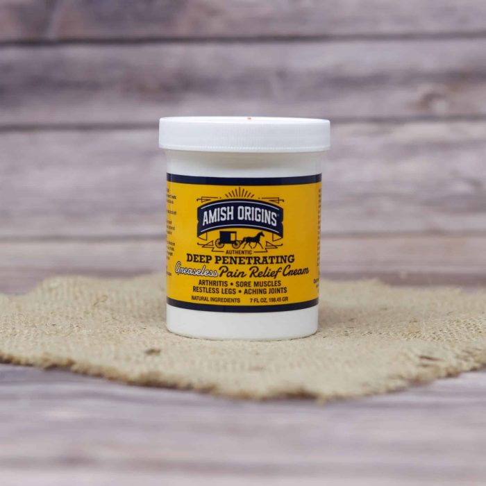 A 7 oz container of Amish Origins Greaseless Pain Relief Cream, set on rustic burlap with a wooden background.