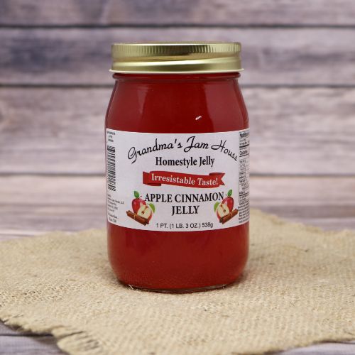 An 18oz glass jar of Grandmas Jam House Apple Cinnamon Jelly, on rustic burlap with a wooden background.