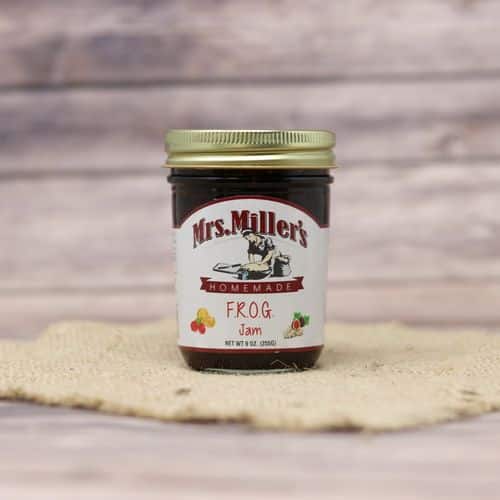 A 9 oz glass jar of Mrs. Miller's Frog Jam, on rustic burlap with a wooden background.
