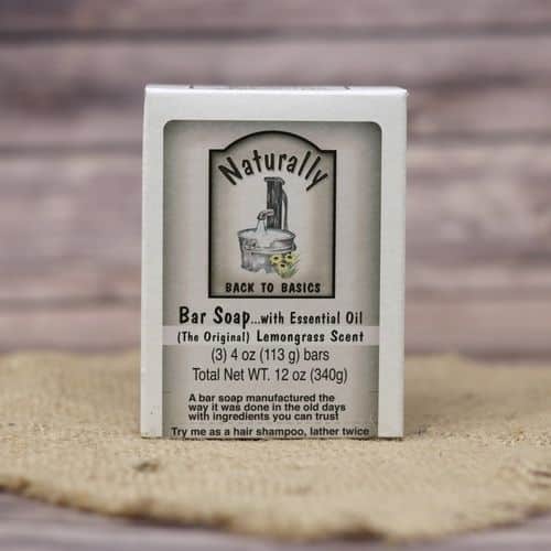 A box of 3 bar soaps with essential oils, set on rustic burlap with a wooden background.