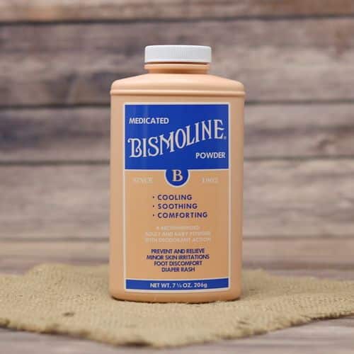 A 7.25 oz bottle of Bismoline Powder, set on rustic burlap with a wooden background.