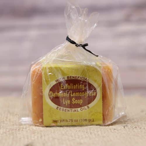 Oatmeal Lemongrass Bar Soap in a plastic bag closed with a twist tie, set on rustic burlap with a wooden background.