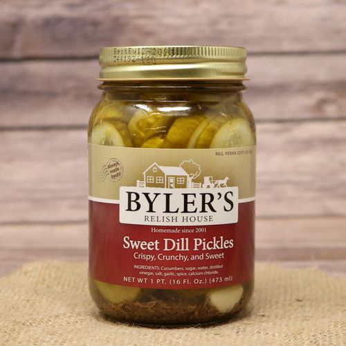 A pint size glass jar of Byler's Relish House Sweet Dill Pickles, on rustic burlap with a wooden background.