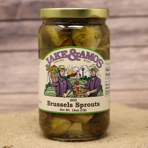 A pint size glass jar of Jake & Amos Dill Brussels Sprouts, on rustic burlap with a wooden background.