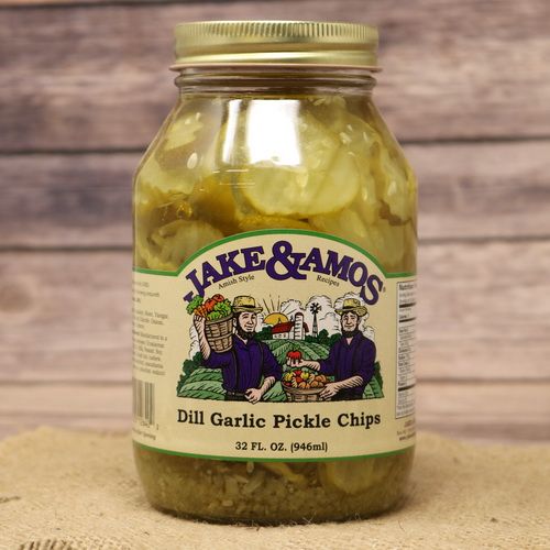 A quart size glass jar of Jake & Amos Dill Garlic Pickle Chips, on rustic burlap with a wooden background.