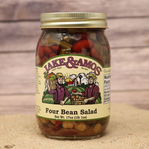 A pint size glass jar of Jake & Amos Four Bean Salad, on rustic burlap with a wooden background.