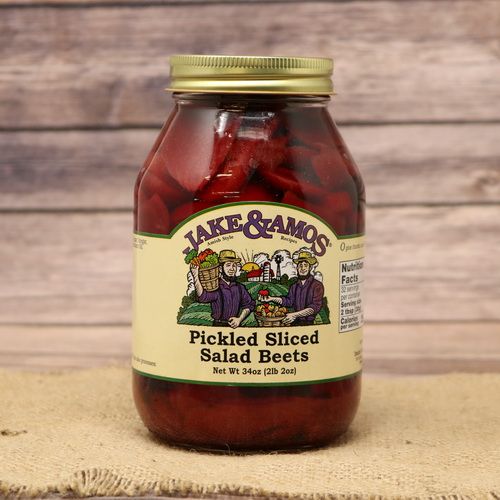 A quart size glass jar of Jake & Amos Pickled Sliced Salad Beets, on rustic burlap with a wooden background.