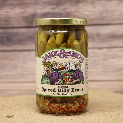 A pint sized glass jar of Jake & Amos Spiced Dilly Beans, on rustic burlap with a wooden background.