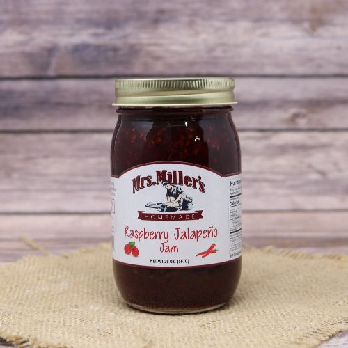 A 20oz glass jar of Mrs. Miller's Homemade Raspberry Jalapeno Jam, on rustic burlap with a wooden background.