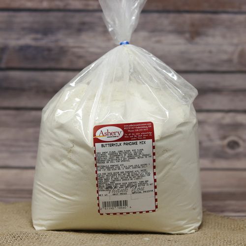 A clear plastic bag sealed with a twist tie with Buttermilk Pancake Mix on rustic burlap with a wooden background.