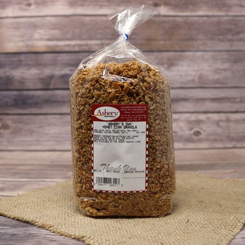 A clear plastic bag of Honey Cinnamon Granola sealed with a twist tie on rustic burlap with a wooden background.