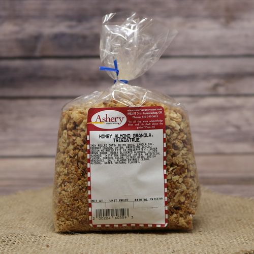 A clear bag of Honey Almond Granola on rustic burlap with a wooden background.