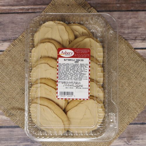 A clear container of Buttermilk Cookies, with a rustic wooden background on burlap