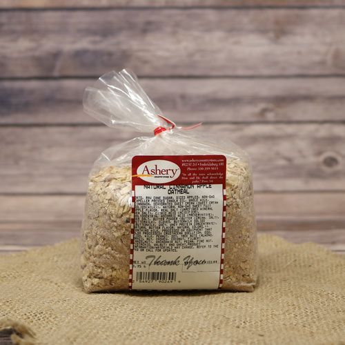 A clear plastic bag sealed with a red twist tie of Cinnamon Apple Oatmeal on rustic burlap with a wooden background.