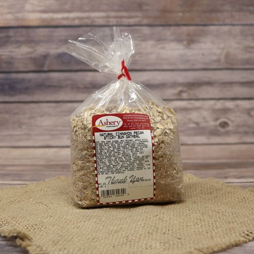A clear plastic bag sealed with a twist tie of Cinnamon Pecan Sticky Bun Oatmeal on rustic burlap with a wooden background.