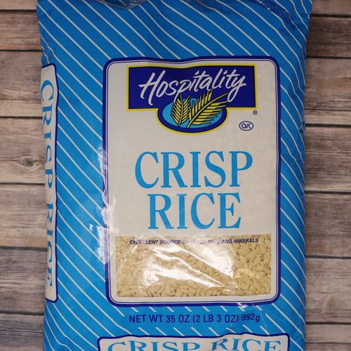 A blue bag containing 35 ounces of Crisp Rice which is a cereal on rustic burlap with a wooden background.