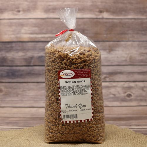 A clear bag of Grate Nuts Granola sealed with a twist tie on rustic burlap with a wooden background.