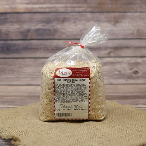 A clear plastic bag sealed with a twist tie of Maple And Brown Sugar Oatmeal on rustic burlap with a wooden background.