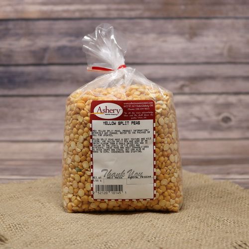 A clear plastic bag of dried Yellow Split Peas sealed with a twist tie on rustic burlap with a wooden background.