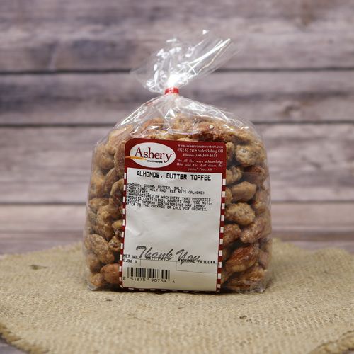 A clear plastic bag of Butter Toffee Almonds, closed with a twist tie and set on rustic burlap with a wooden background.
