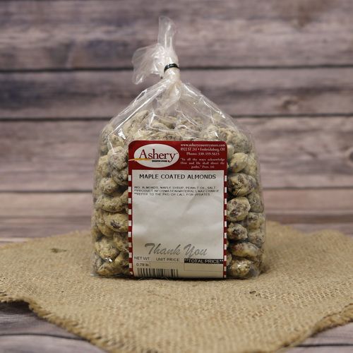 A clear plastic bag of Maple Coated Almonds, closed with a twist tie and set on rustic burlap with a wooden background.