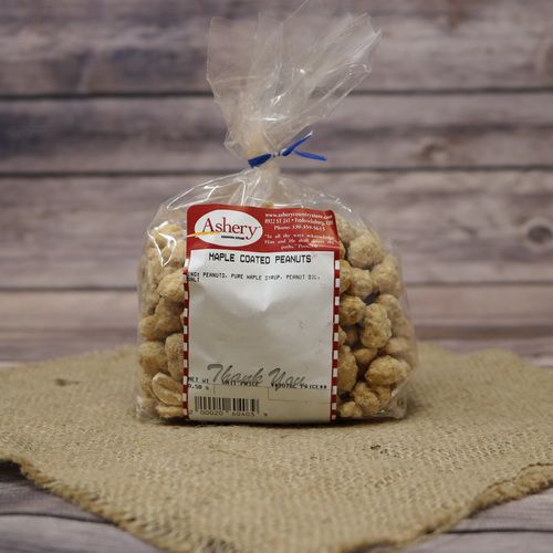 A clear plastic bag of Maple Coated Peanuts, closed with a twist tie and set on rustic burlap with a wooden background.