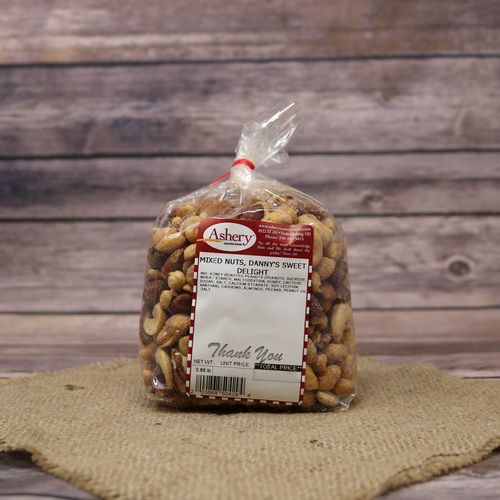A clear plastic bag of Danny's Sweet Delight Mixed Nuts, closed with a twist tie and set on rustic burlap with a wooden background.