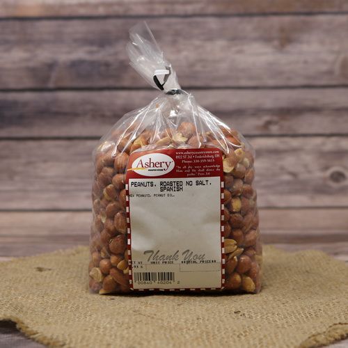A clear plastic bag of Roasted No Salt Spanish Peanuts, closed with a twist tie and set on rustic burlap with a wooden background.