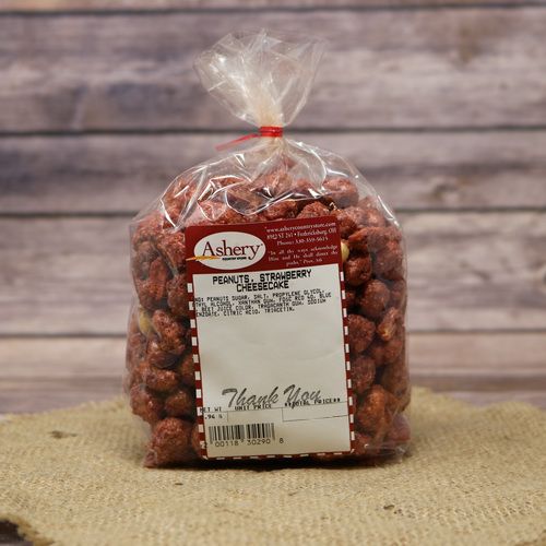 A clear plastic bag of Strawberry Cheesecake Peanuts, closed with a twist tie and set on rustic burlap with a wooden background.