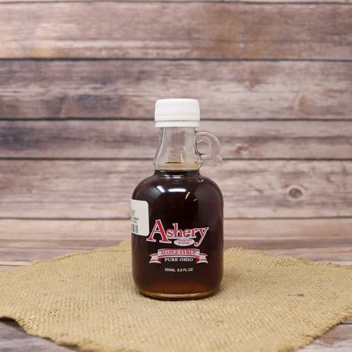 An 8.5 oz glass bottle of Pure Ohio Maple Syrup, set on rustic burlap with a wooden background.