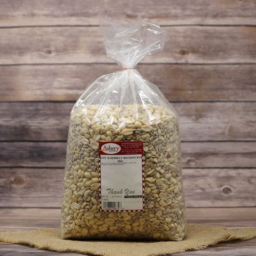 A large bag of Nuts N Kernels Woodpecker Mix on rustic burlap with a wooden background.