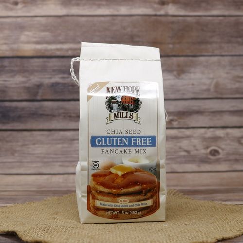 A white bag of Gluten Free Chai Seed Pancake Mix on rustic burlap with a wooden background.
