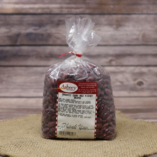 A clear bag of Organic Dark Red Kidney Beans sealed with a twist tie on rustic burlap with a wooden background.