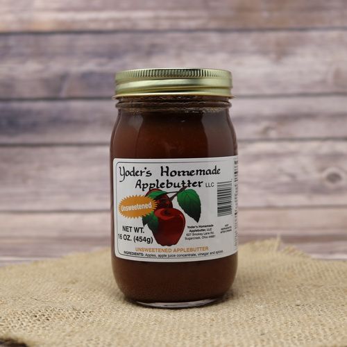 A 16oz glass jar of Yoder's Homemade Unsweetened Apple Butter, on rustic burlap with a wooden background.