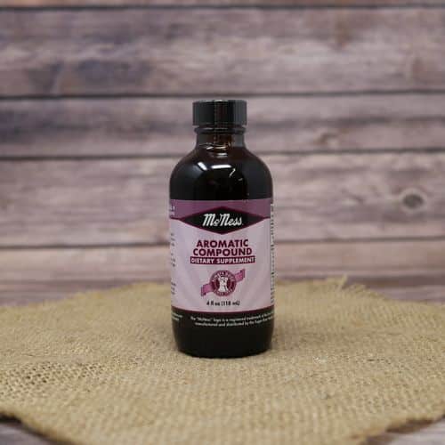 A 4 oz glass bottle of Aromatic Compound, set on rustic burlap with a wooden background.