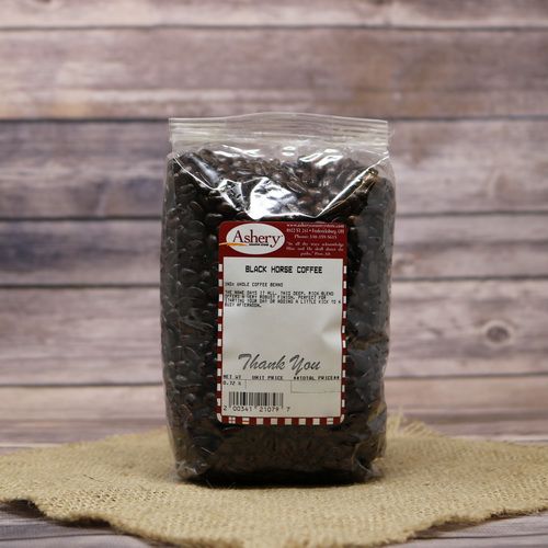 A clear bag of Black Horse Coffee beans on rustic burlap with a wooden background.