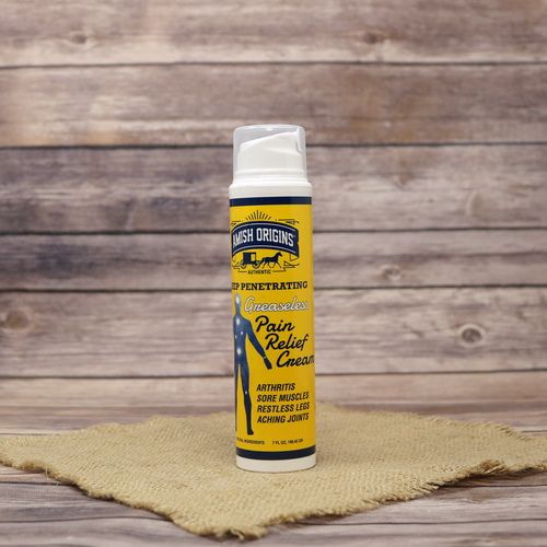 A pump bottle of Amish Origins Greaseless Pain Relief Cream, set on rustic burlap with a wooden background.