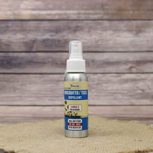 A 2oz spray bottle of Mosquito & Tick Repellent, set on rustic burlap with a wooden background.