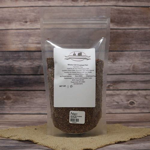 A plastic bag of Whole Cell Crushed Flax Seeds, set on rustic burlap with a wooden background.